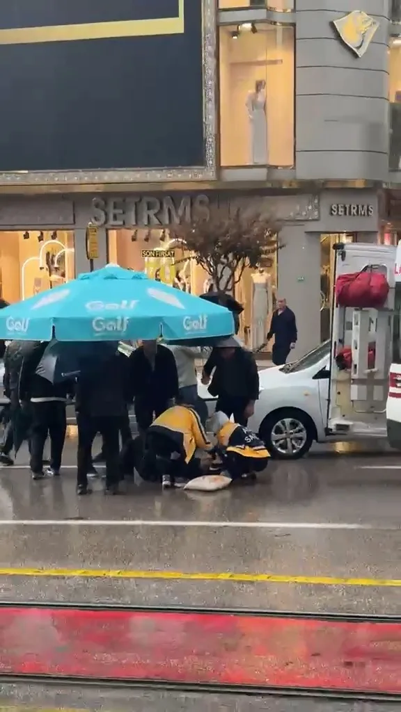Yolun karşısına geçerken otomobil çarptı: Vatandaşlar yaralıya şemsiye tuttu