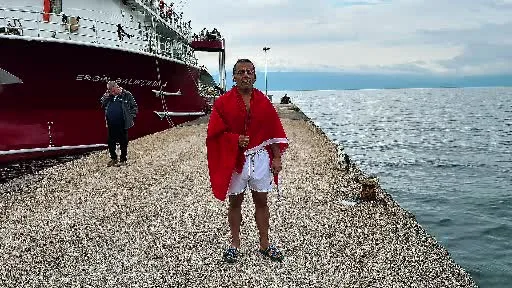 Soğuk ve yağışlı havaya aldırmadı, Türk bayrağıyla denize girdi